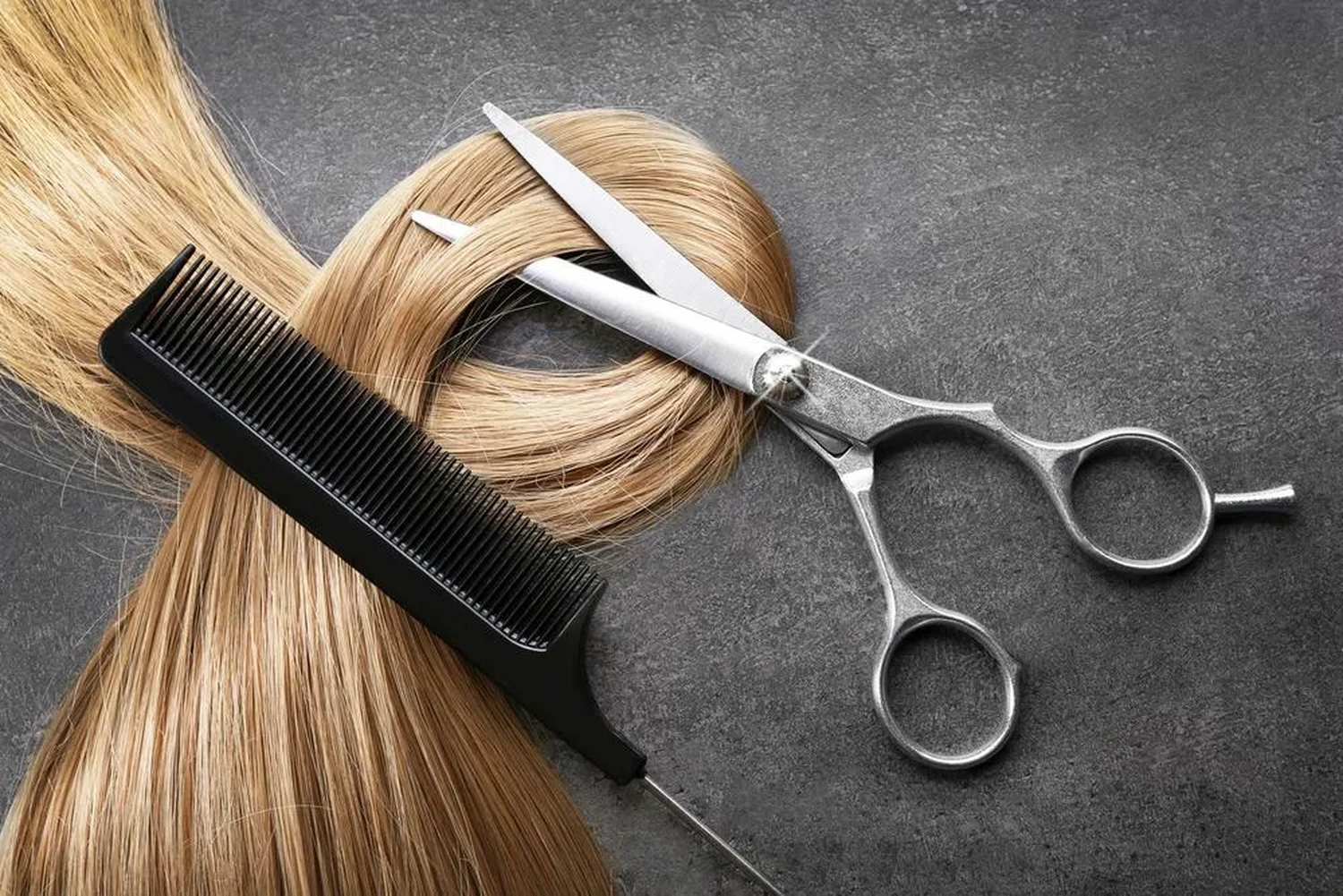 Cjk - Hair Atelier - Friseurschere mit Kamm und blonder Haarsträhne auf grauem Hintergrund